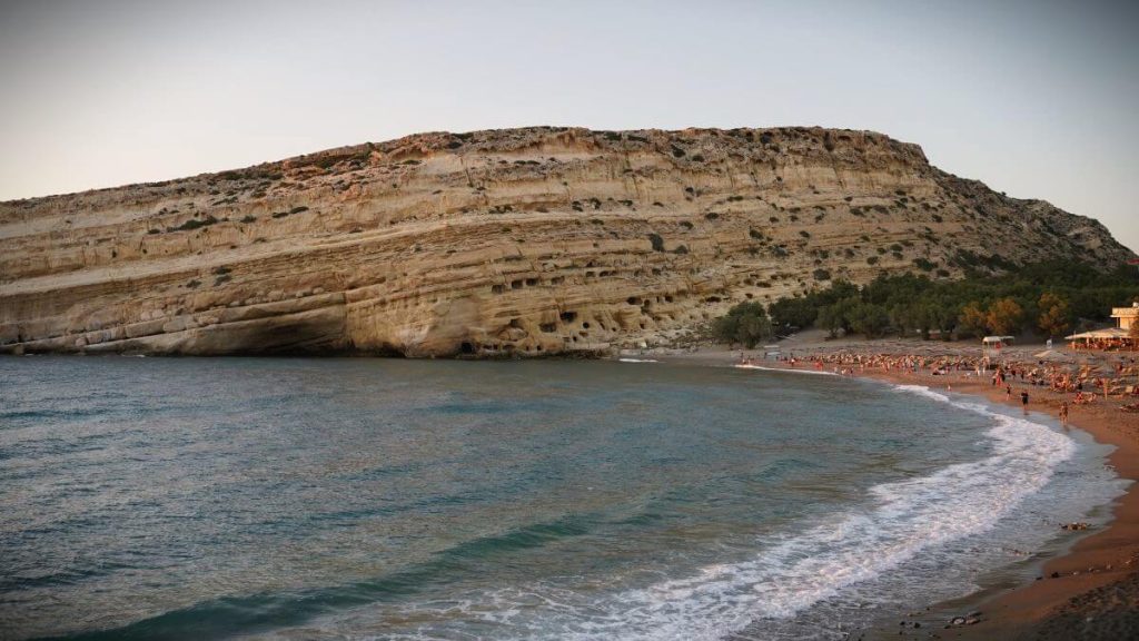 Spiaggia di Matala al tramonto, Creta del sud. Mare azzurro e grotte nelle rocce.