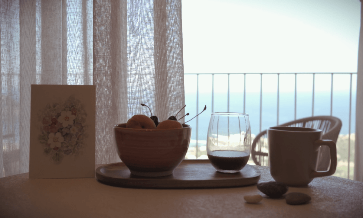 Tavolo con tazza frutta e caffè, in una mattina a Creta con vista mare blu