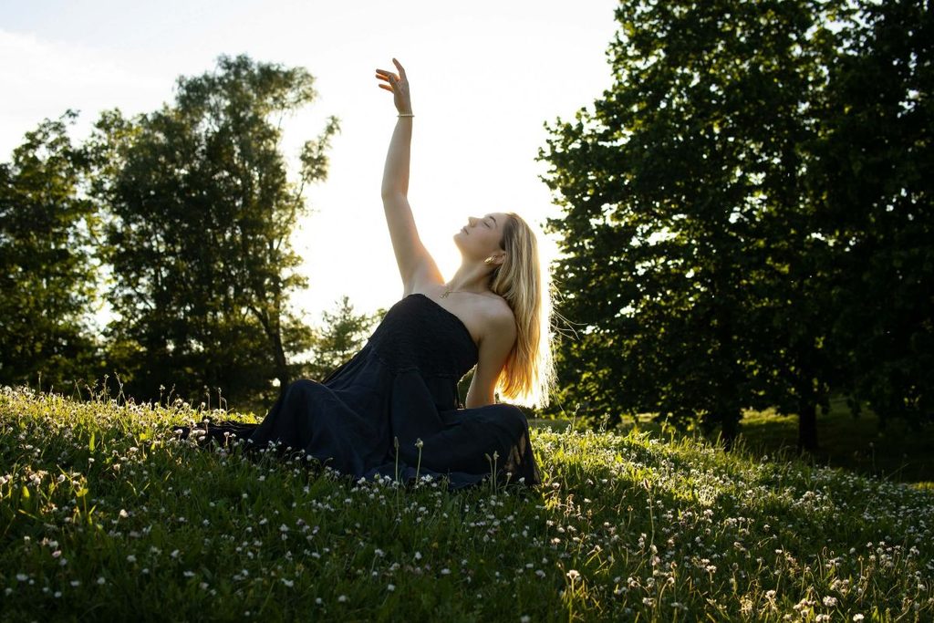 donna che danza con braccia al cielo in un bosco, meditazione in movimento