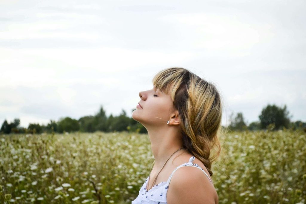 Donna che respira nella natura, meditazione e presenza