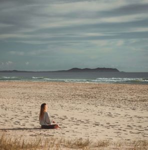 Donna immersa nella natura durante una pratica di meditazione e presenza