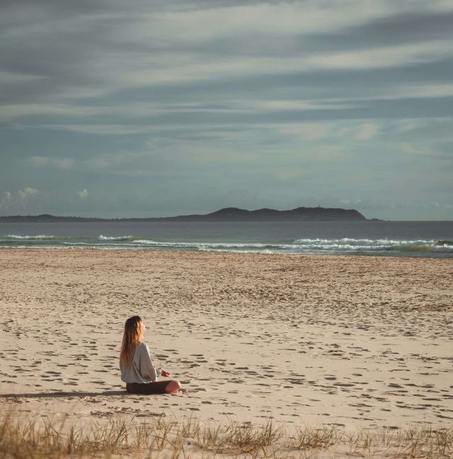Donna immersa nella natura durante una pratica di meditazione e presenza
