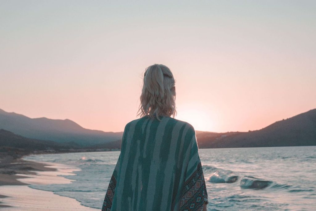 Slow life: donna sulla riva del mare al tramonto