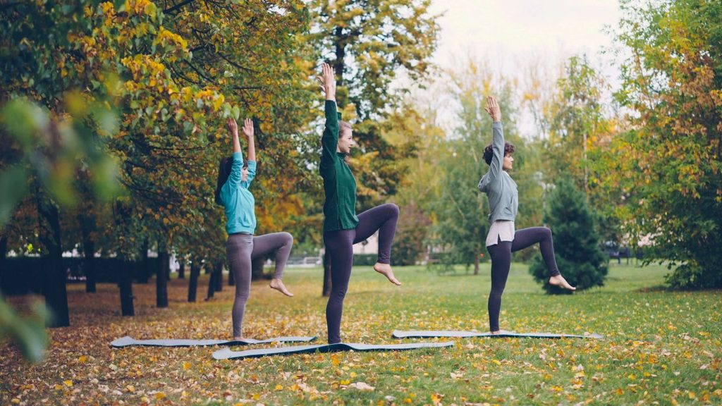 pratica yoga in gruppo all'aperto, movimento consapevole